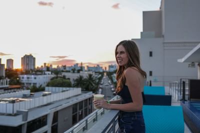 A lady overlooking the city from the balcony at Fairwind Hotel Miami