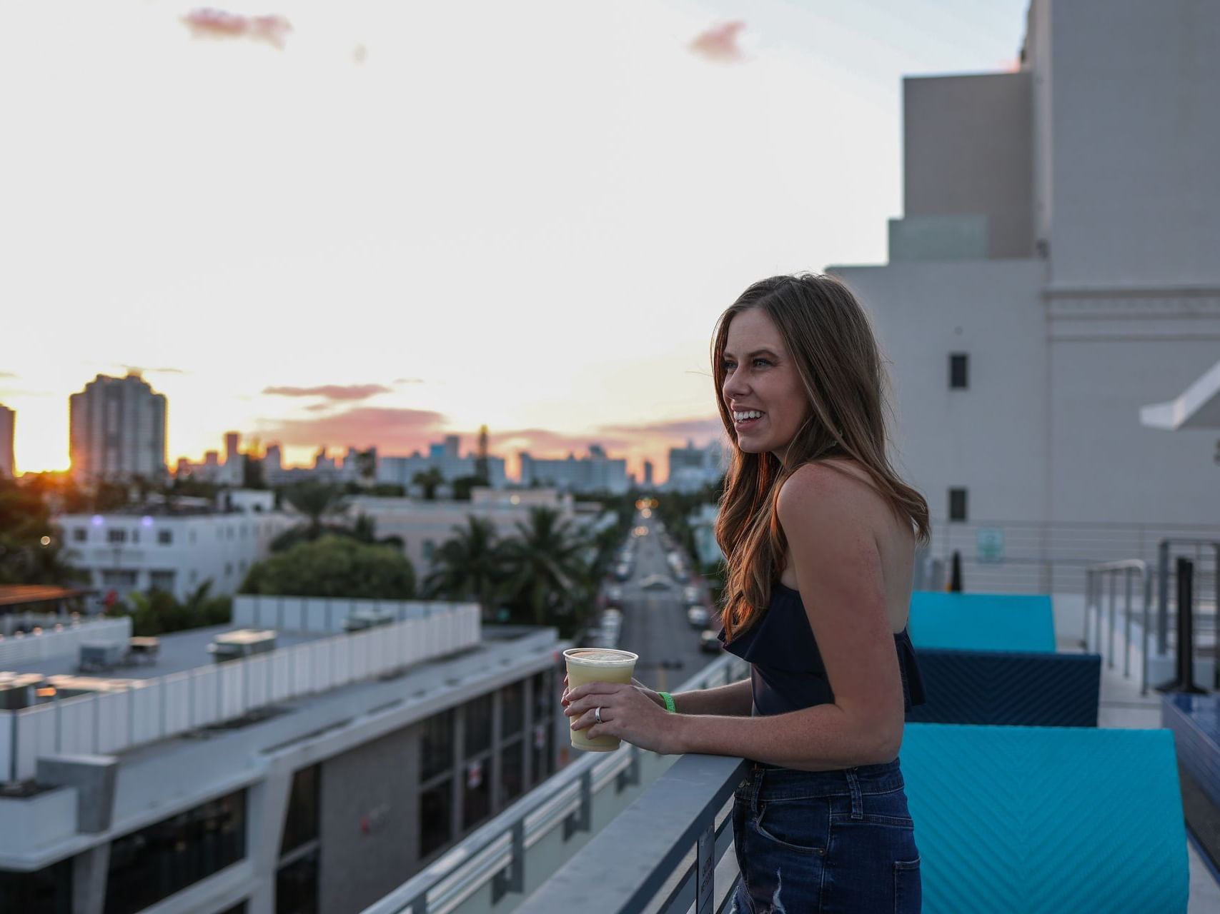 A lady overlooking the city from the balcony at Fairwind Hotel Miami