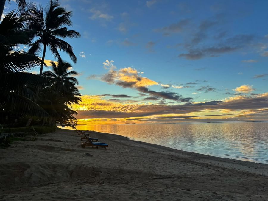 Beach sunset with lounge chairs at Warwick Fiji Resort and Spa in Korolevu