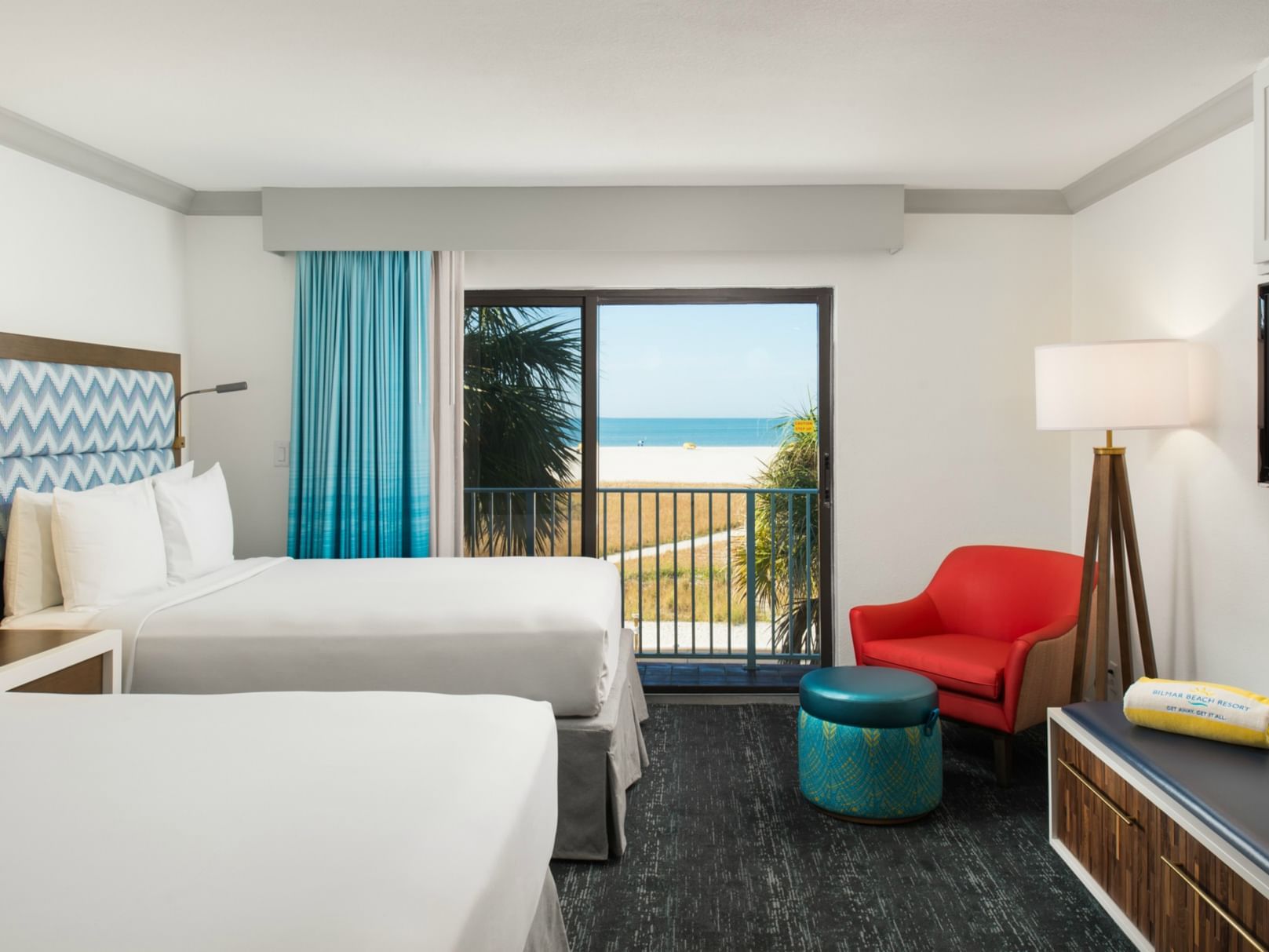 Beds and seating area in Beachfront Premium Studio with carpeted floors at Bilmar Beach Resort