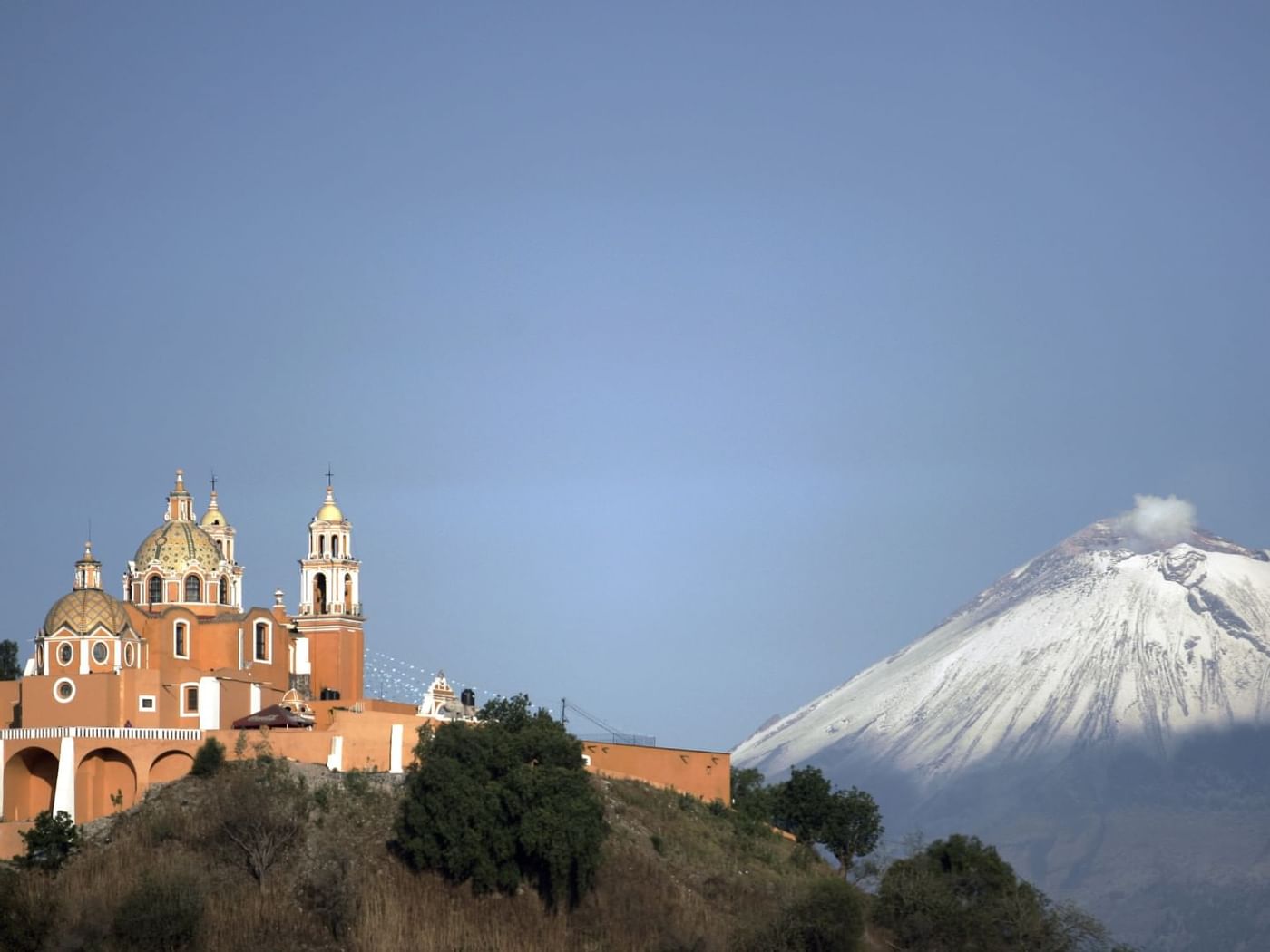 Vista del volcán de Puebla y una iglesia católica cerca del Fiesta Inn