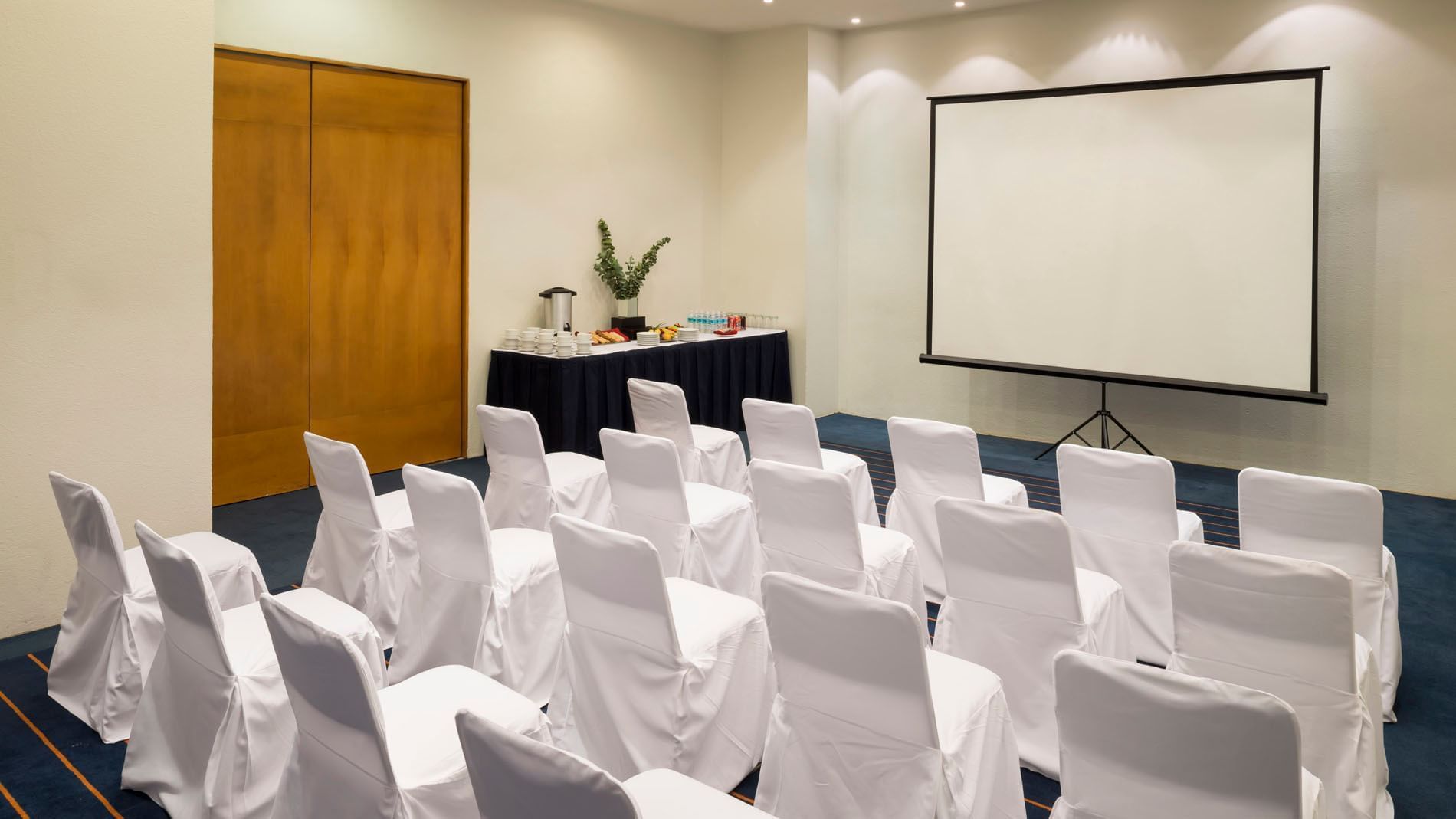 Theatre set-up with a refreshment corner and projector screen in the Milan Venue at Real Inn San Luis Potosi