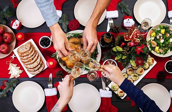 Top view of people toasting wine glasses over a Christmas dinner at The Danna Langkawi