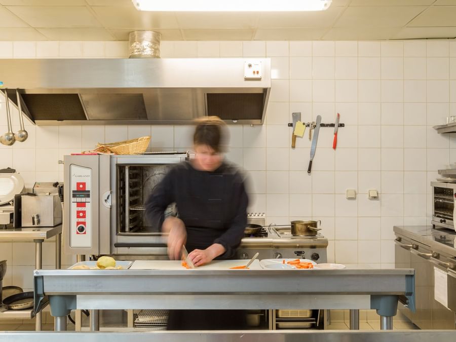 A chef preparing foods in the kitchen of Hotel Spa