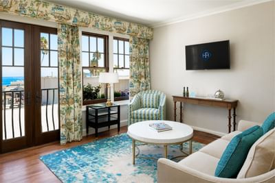 Living area with cozy loungers and a TV in Philip Knight Suite at Hotel Atwater Avalon