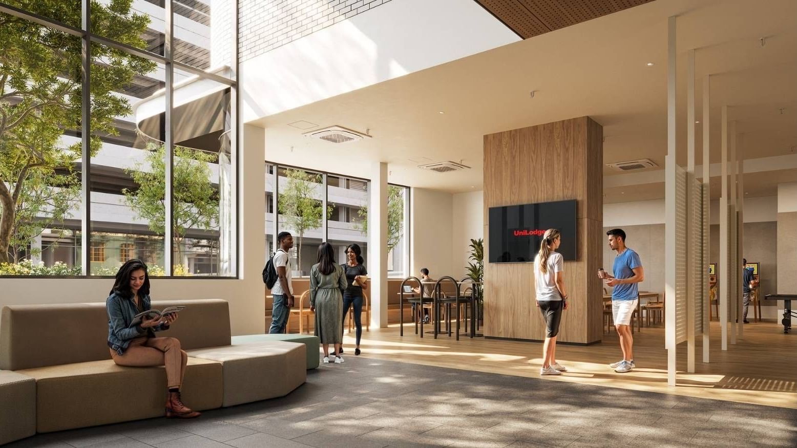 Modern lobby with people, large windows, furniture, and a TV displaying 