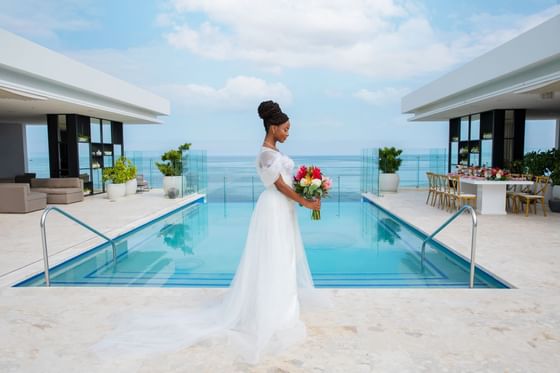 Bride posing by a pool in The Terrace at Alaia Belize Autograph Collection