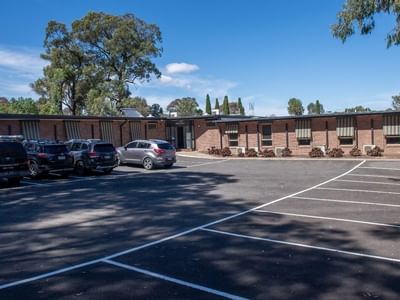 Several cars parked in front of La Trobe University - Orde House building.