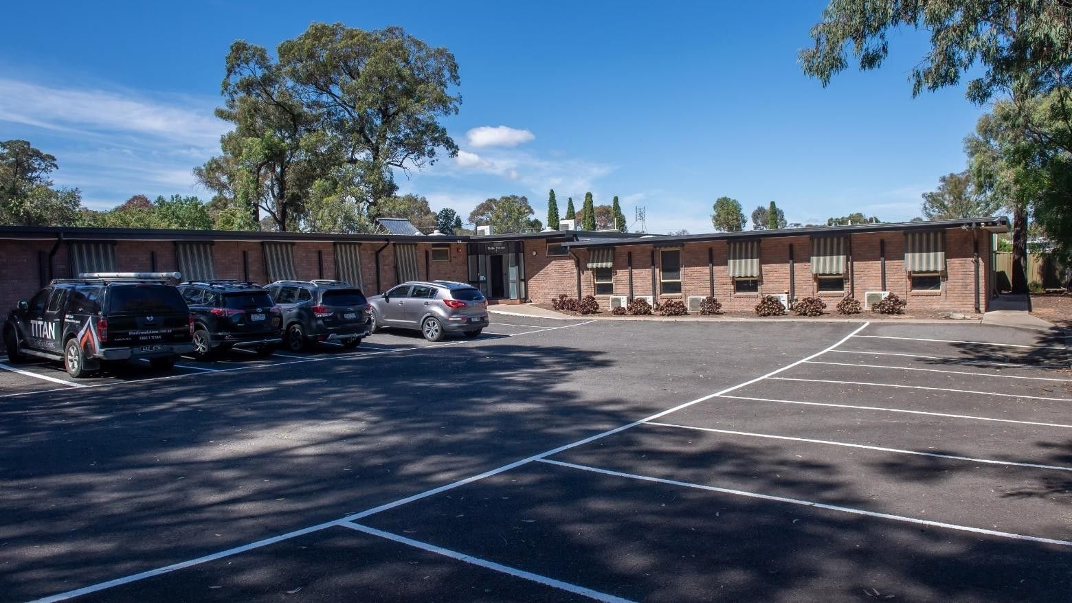 Several cars parked in front of La Trobe University - Orde House building.