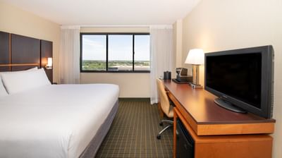 Bed, TV & desk in a room at NCED Hotel and Conference Center
