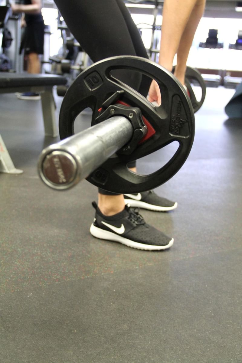People holding a heavy weightlifting barbell on the floor at Hotel 43 Boise