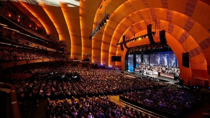 Interior of Radio City Music Hall with rows of plush seats set by a stage near Warwick Hotels & Resorts