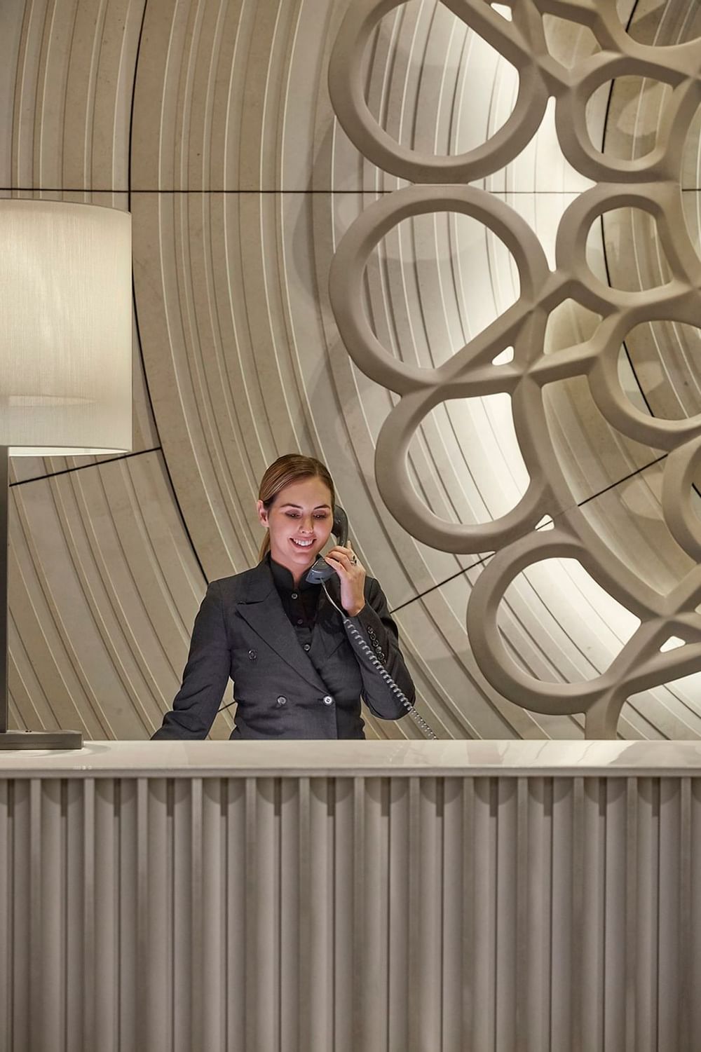 A receptionist by the reception desk at Crown Hotels