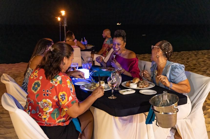Group of friends having dinner by the beach at Amsterdam Manor