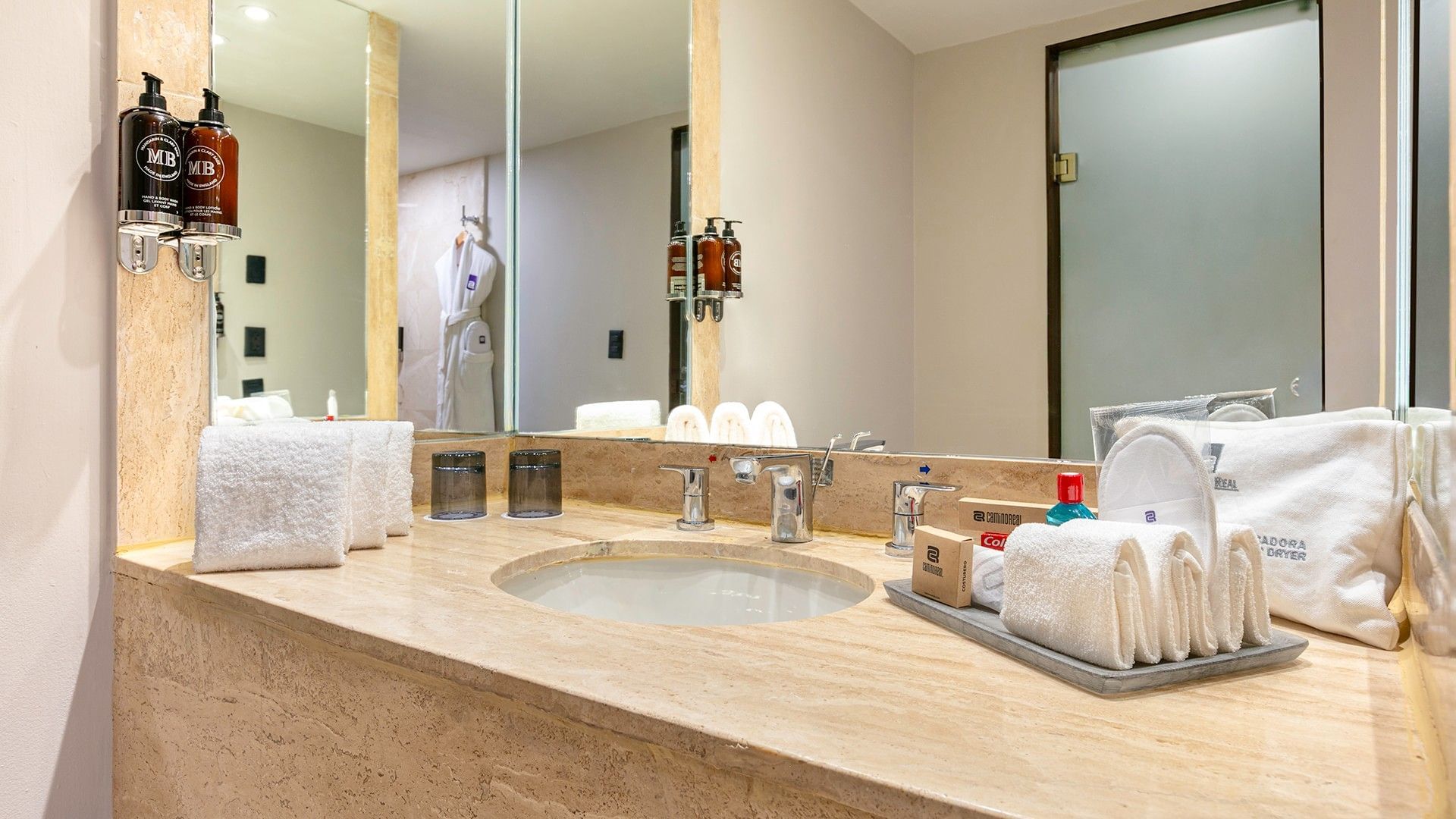 Baño elegante con toallas y amenidades en la Junior Suite 2 Camas Dobles del Camino Real Aeropuerto México en Ciudad de México.