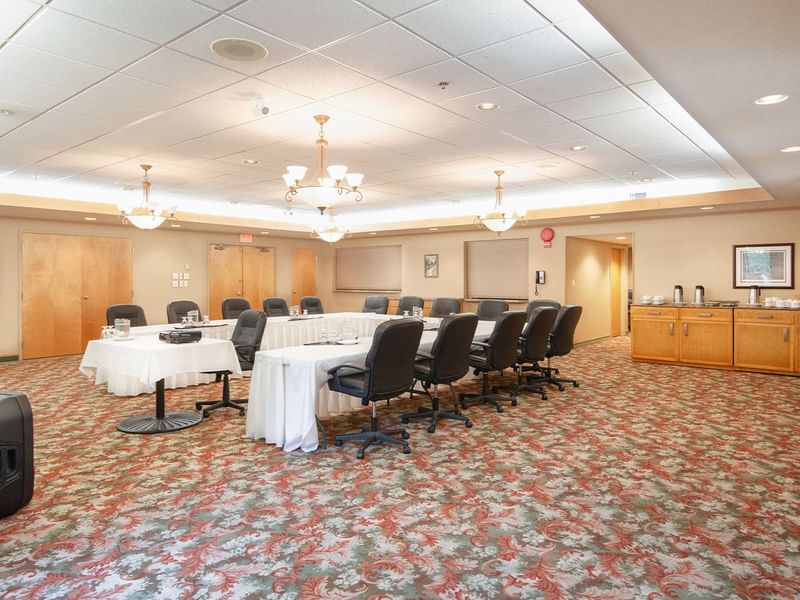 Meeting room with tables, chairs, and projector