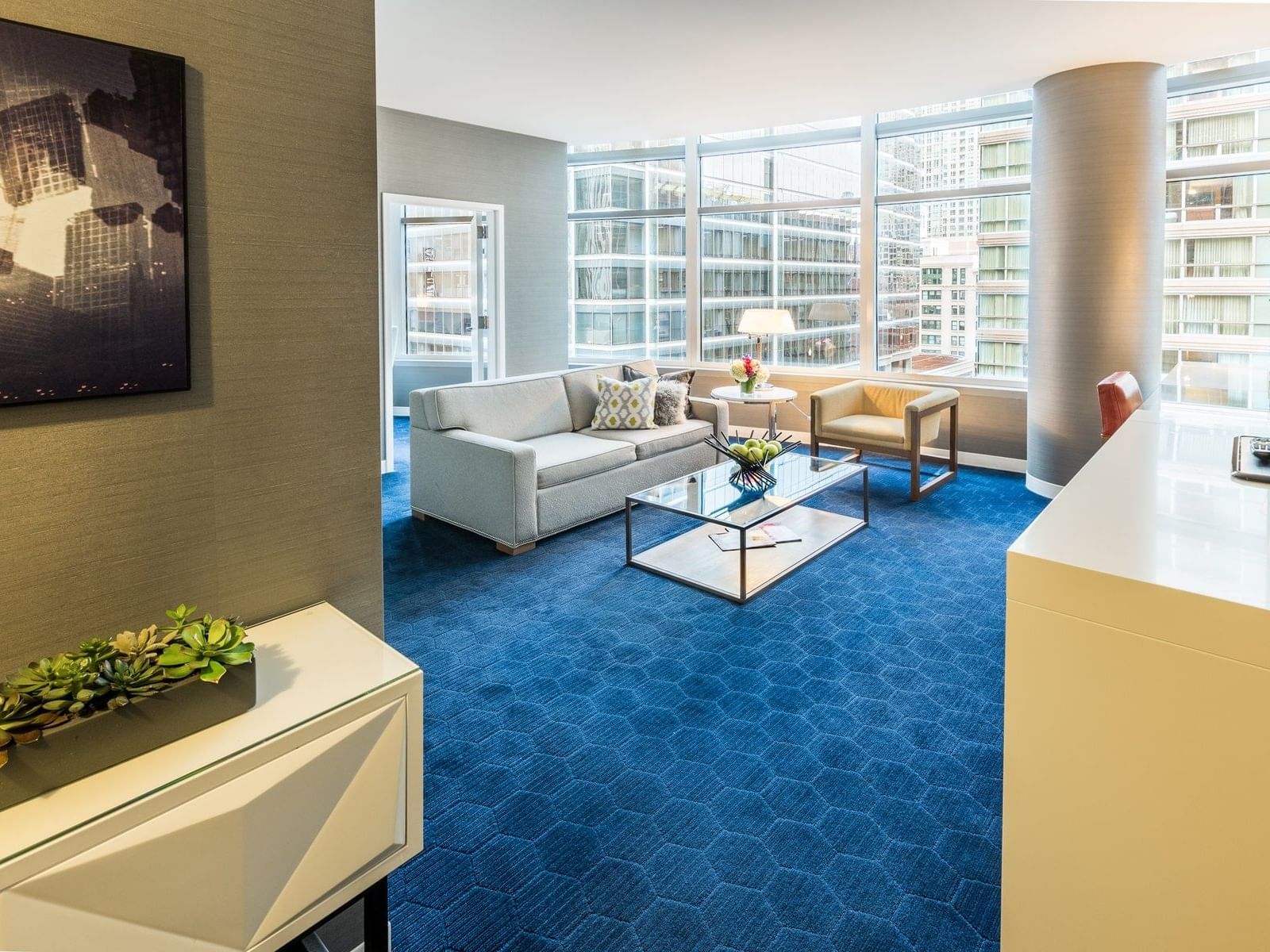 living room of hotel room with large windows overlooking downtown