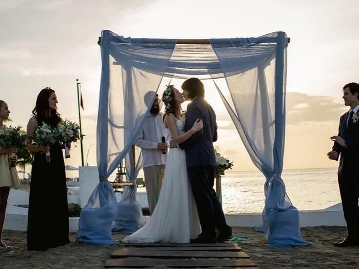 Novios besándose en el altar en una boda en la playa en FA Hotels