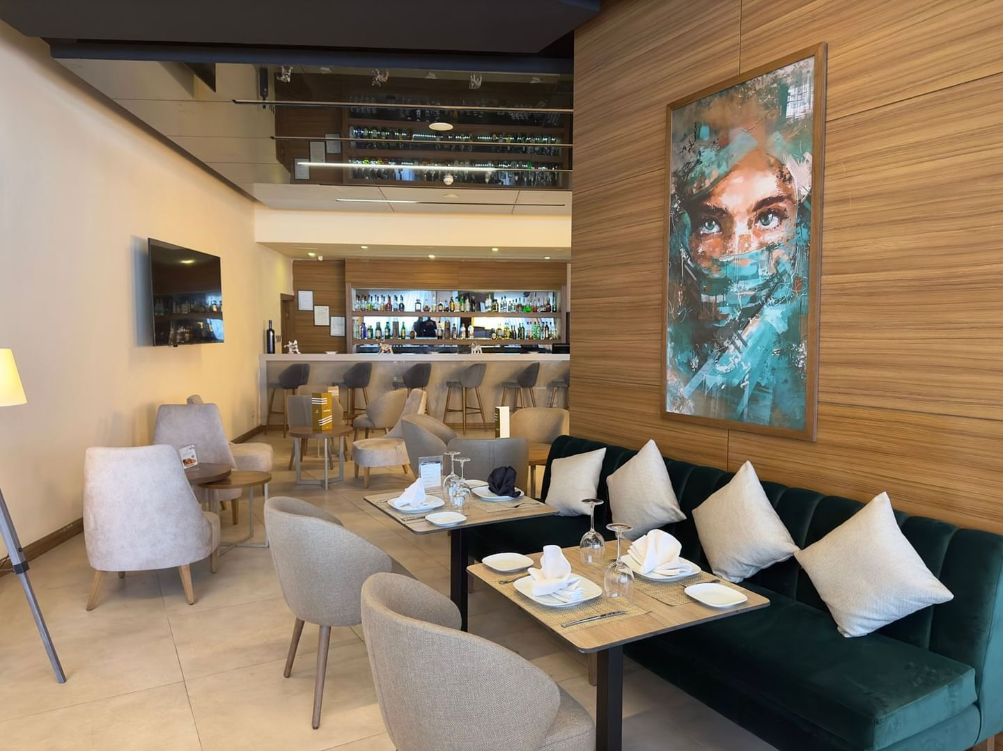 Dining area with tables, chairs, and modern art piece on wall at Kenzi Basma