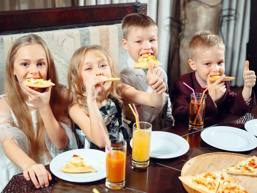 Children eating pizza in the restaurant at MCM Eleganté Suites