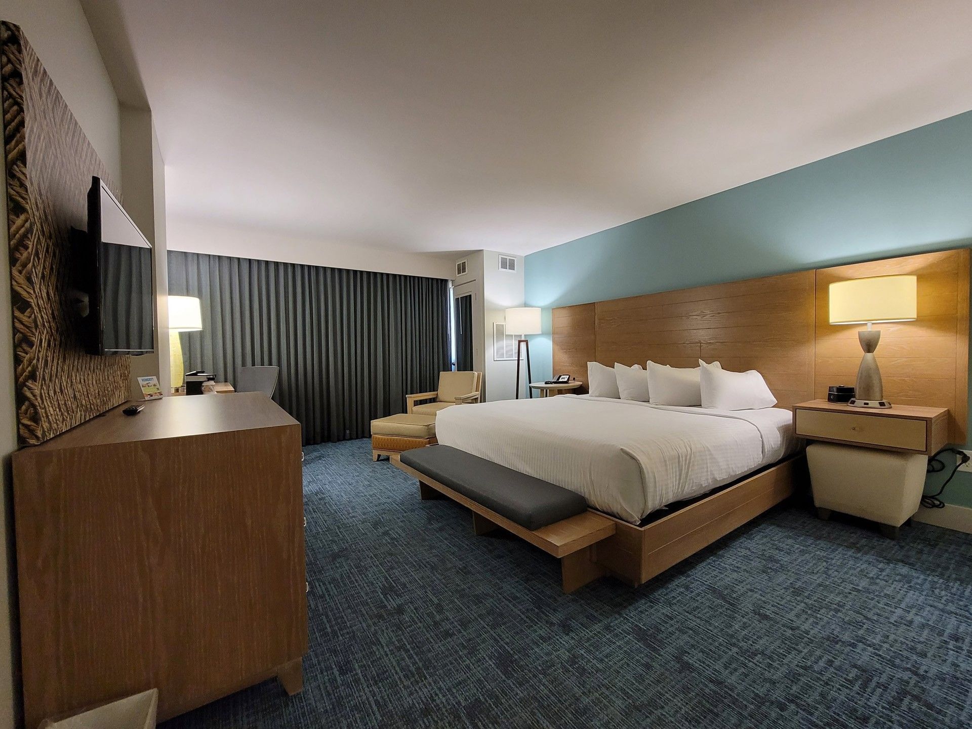 King Room No Balcony at Margaritaville Resort Biloxi with teal accents, a sitting chair, and ambient lamps