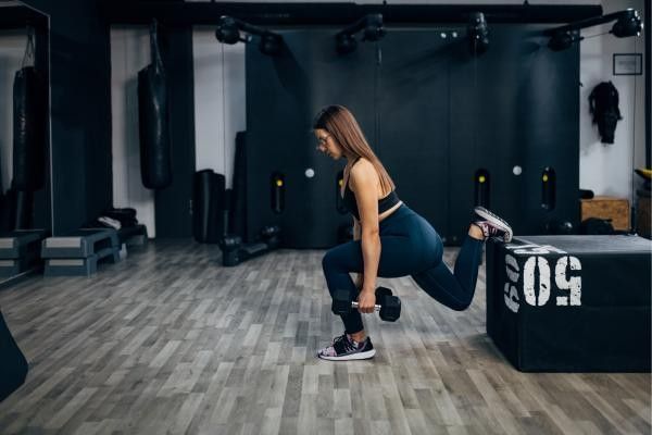 Woman performing dumbbell Bulgarian split squats