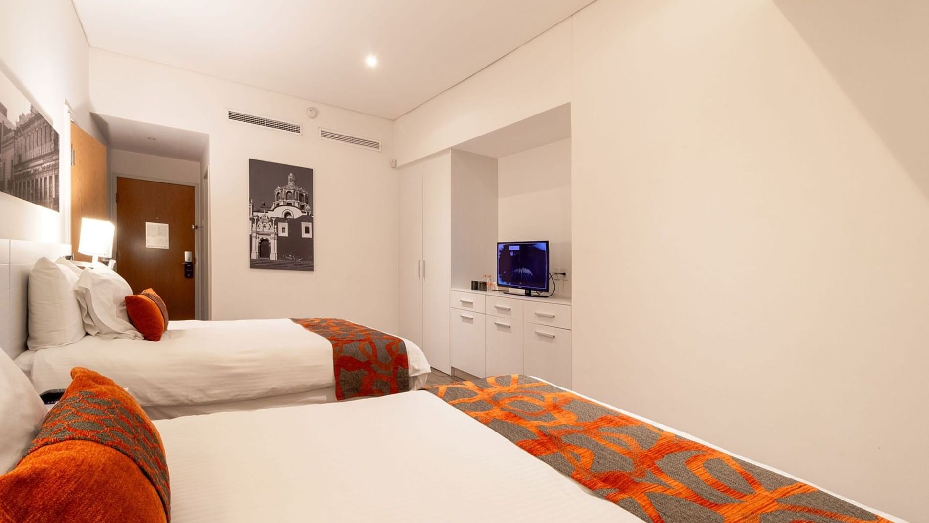 King Suite 2 Rooms with white walls and orange bed accents at Camino Real Puebla Angelopolis