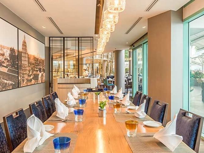 Long dining table with an elegant lighting setting of River Barge Restaurant at Chatrium Hotel Riverside Bangkok