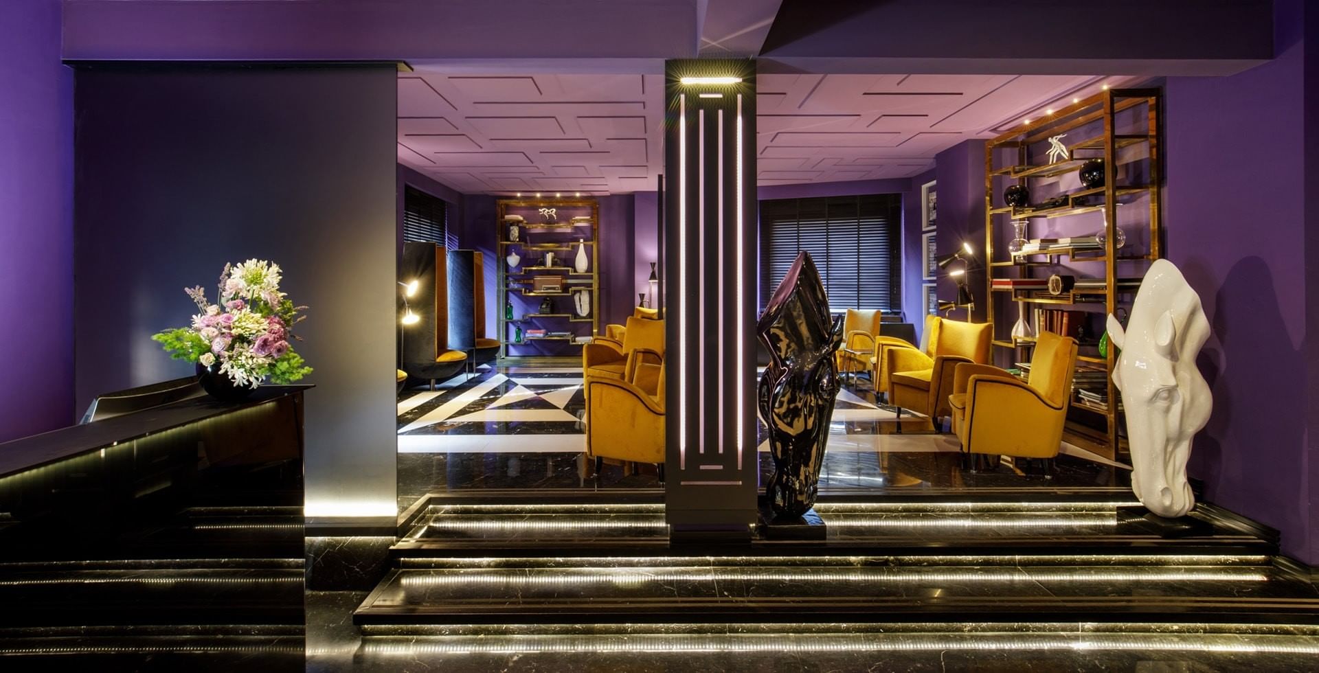 Stylish lobby of Tribune Hotel Rome with modern design, marble floors, contemporary art, and elegant seating area creating a welcoming atmosphere