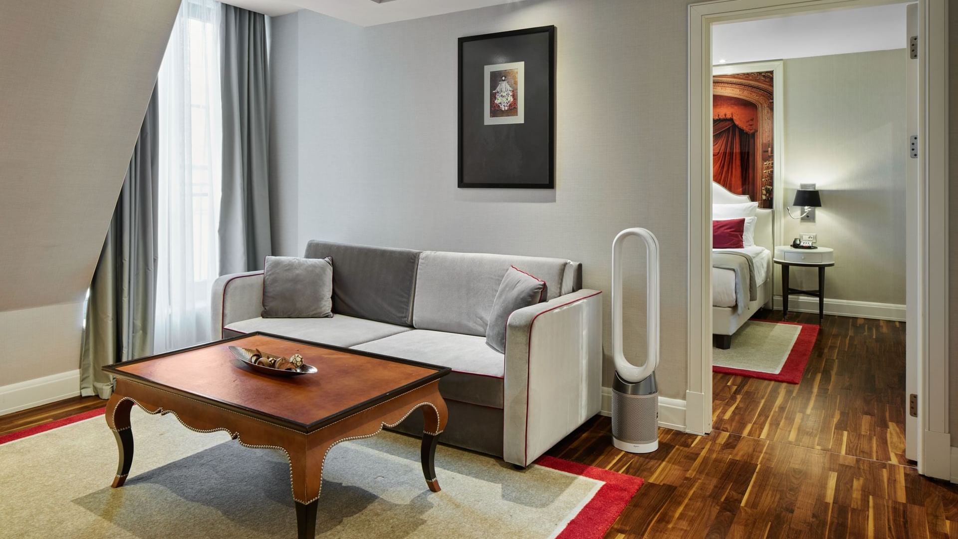 Titanic Suite mit Wohnbereich, Holzboden und Sofa im Titanic Gendarmenmarkt Berlin.