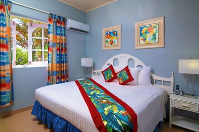 Cozy bed with side tables and air conditioner in One Bedroom Garden Pool View at Dover Beach Hotel