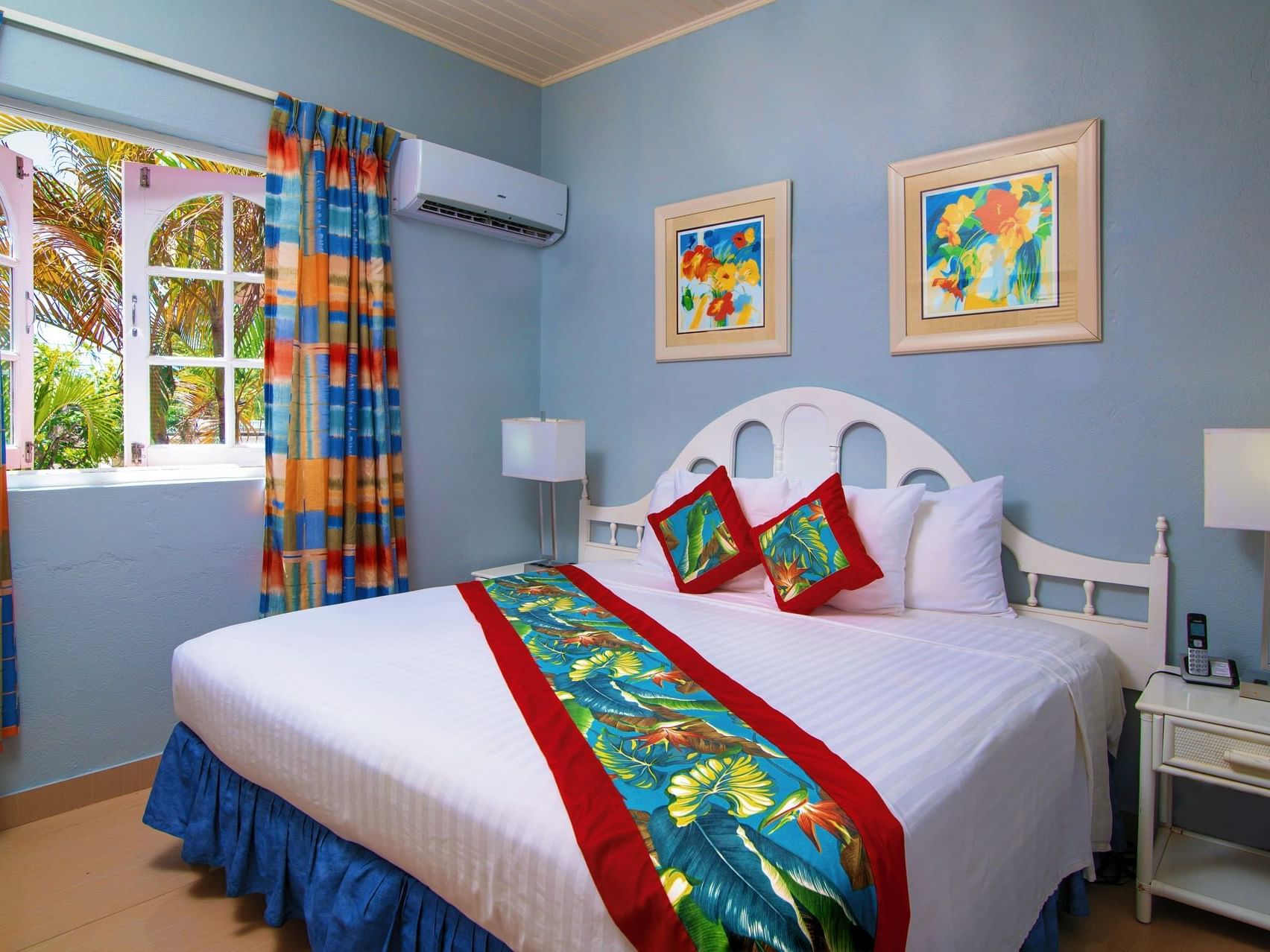 Cozy bed with side tables and air conditioner in One Bedroom Garden Pool View at Dover Beach Hotel