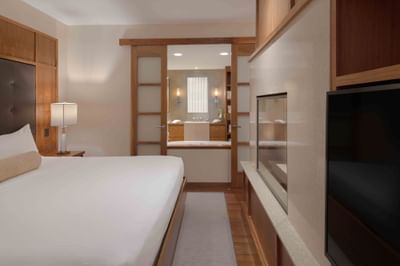 TV facing the bed in Executive Suites with wooden accents at Portland Harbor Hotel