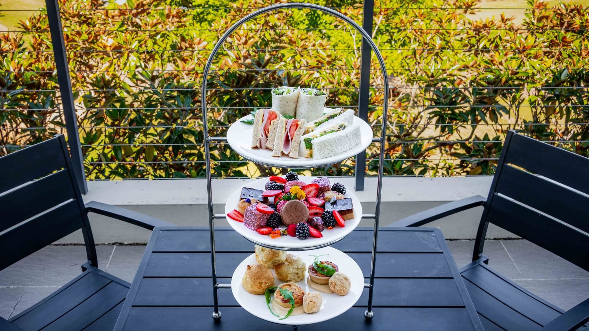 Three-tiered High Tea stand with pastries, and sandwiches at Mercure Kooindah Waters