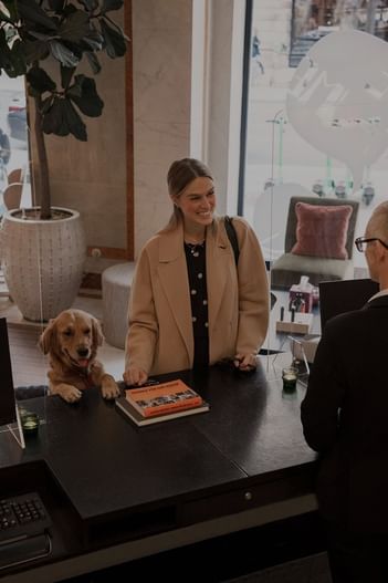 Woman and dog checking in at hotel reception at The Sparrow Hotel