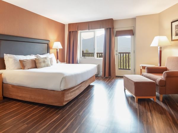 Hotel guest room with king bed, a balcony, and mini fridge