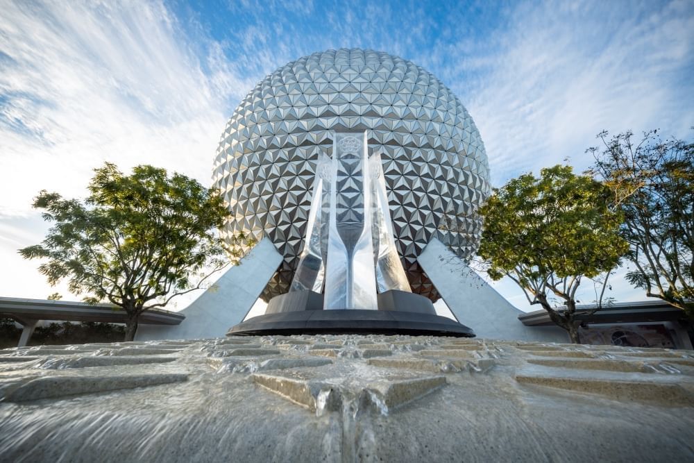 Disney's iconic Spaceship Earth sphere and a glass sculpture with a running waterfall. 