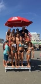 A large group poses for a photo after one of our surf lessons in Diamond Beach