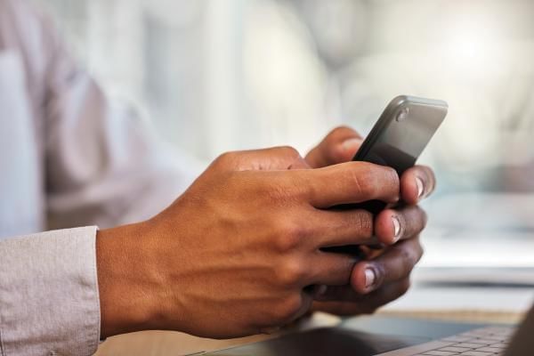 Person on phone using social media to their advantage whilst trying to network at a conference