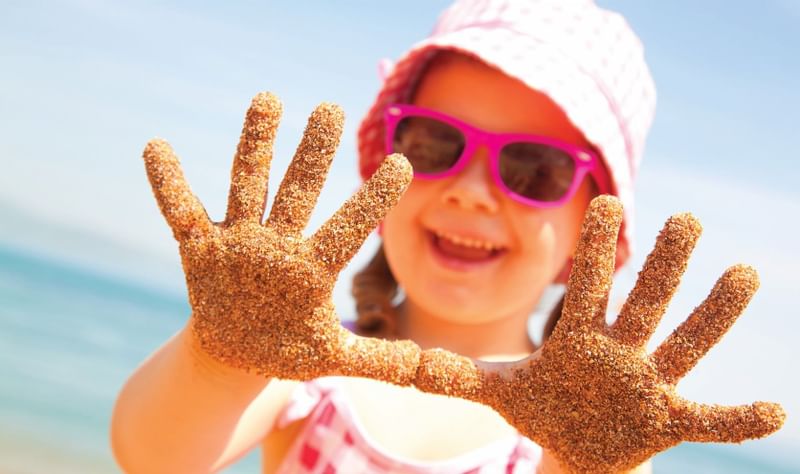 Girl holding sandy hands at the camera, The Diplomat Resort