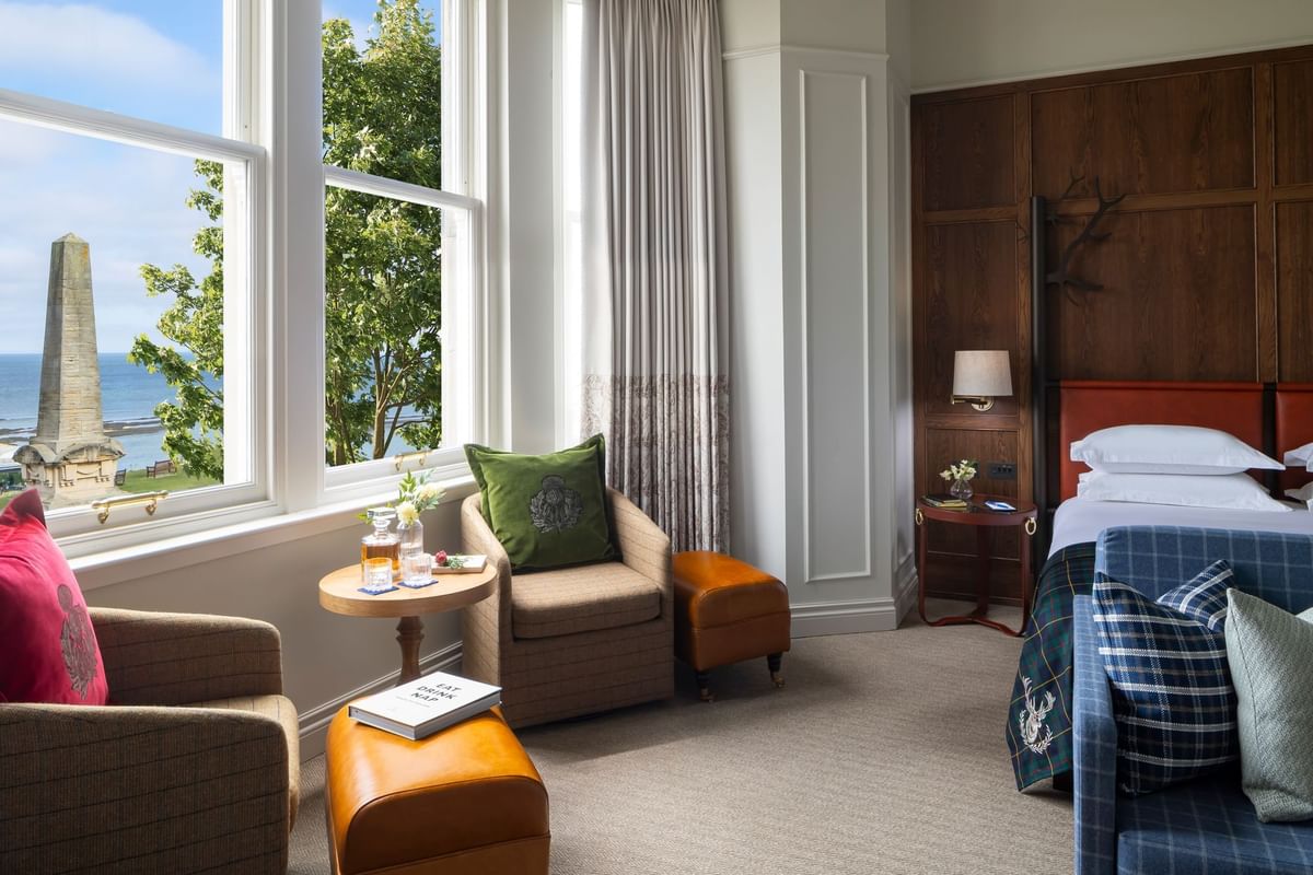 Junior Suite with Sea View with two chairs near a window, overlooking a seaside monument at Seaton House