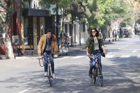 hombre y mujer andando en bicicleta por la calle en barrio lasta