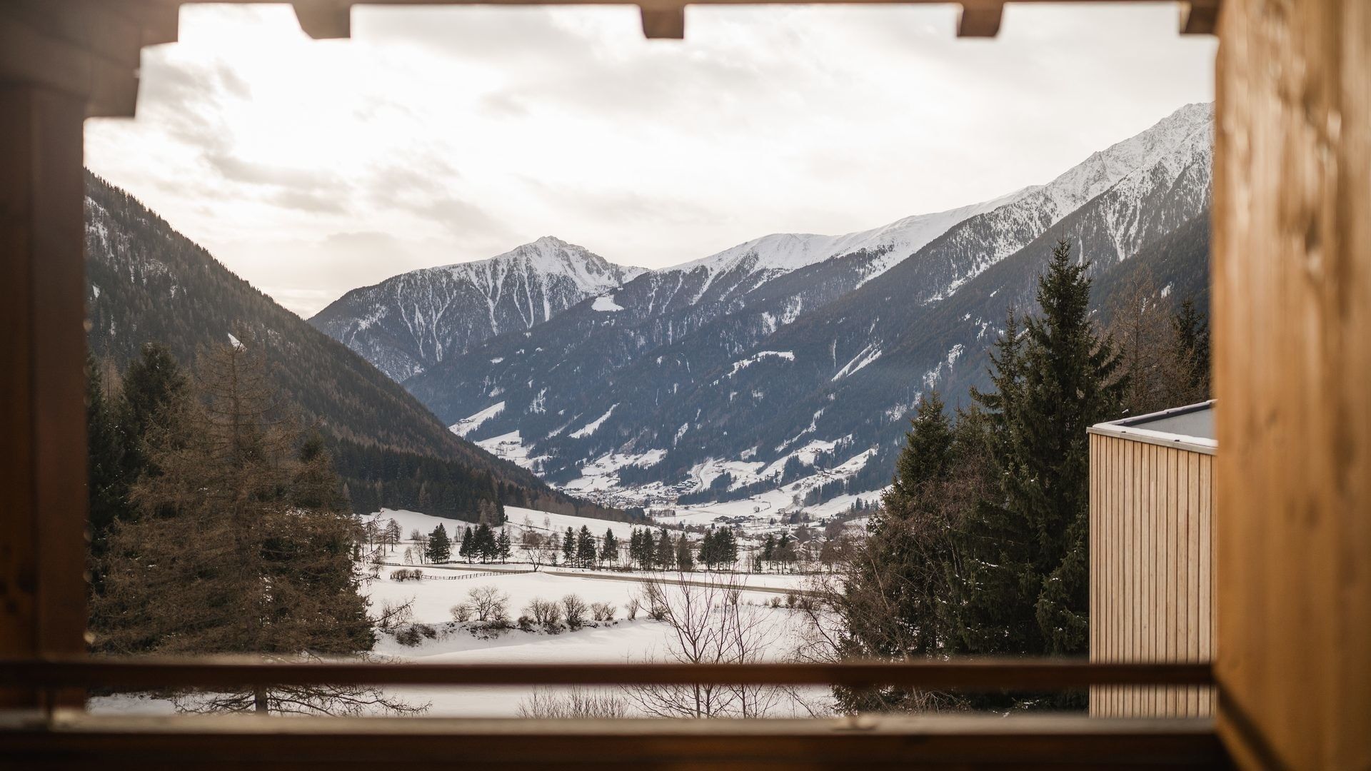 Ausblick auf die schneebedeckten Berge und Wälder von der Premium Suite Bergliebe im Falkensteiner Hotel Antholz.