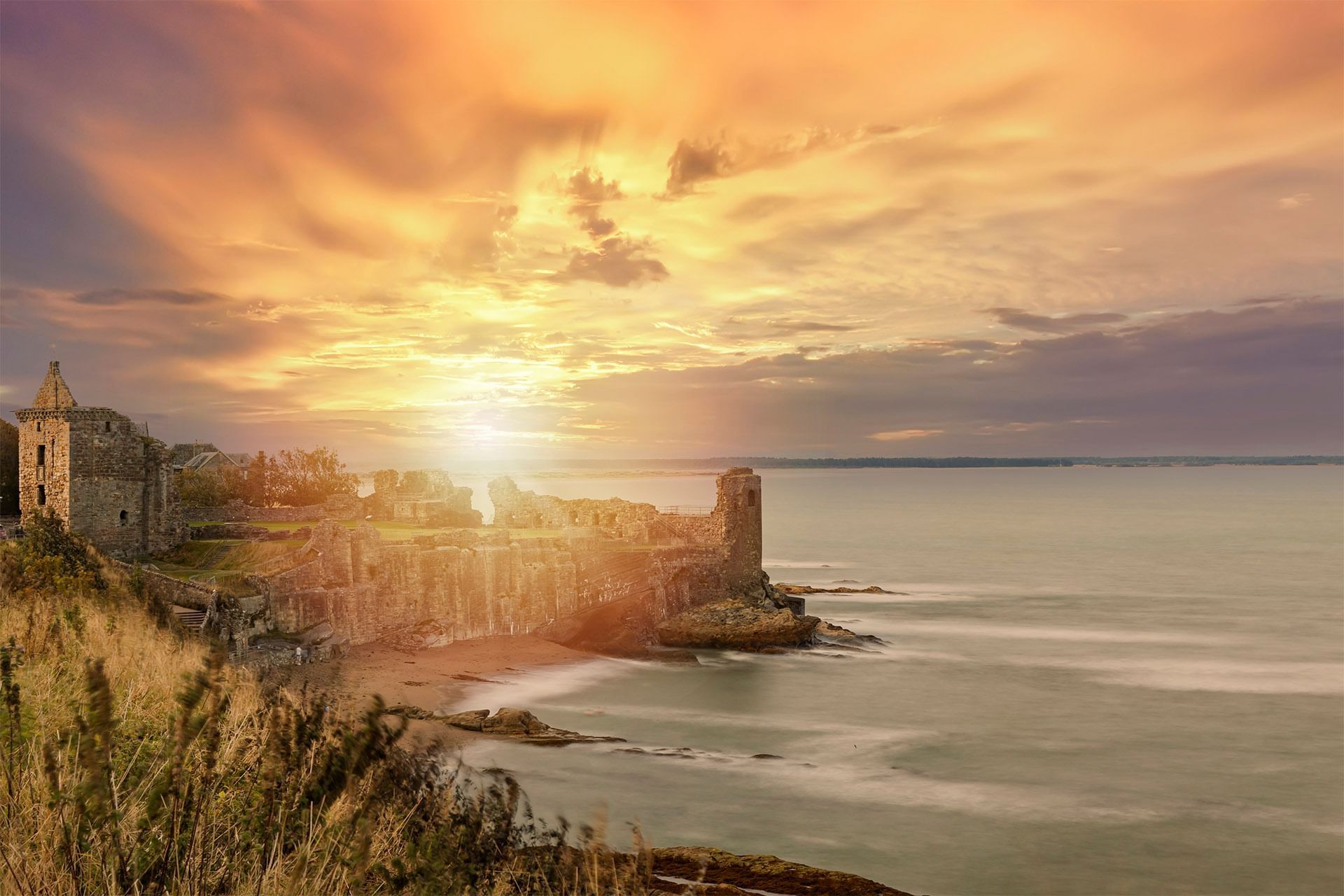 Aerial view of a St Andrews Cathedral with ruins and a cemetery, overlooking a bay near Seaton House