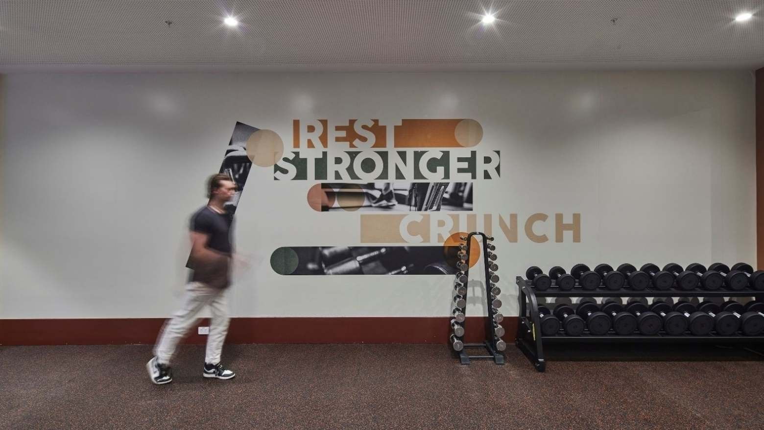 Man walks past gym wall with 