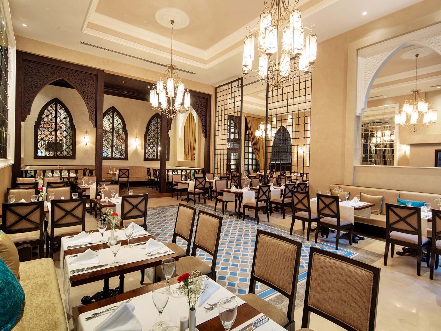 Restaurant interior with tiled floor, and set dining tables at Titanic Deluxe Golf Belek