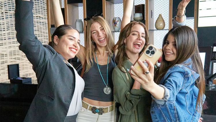 Four women smiling and posing for a selfie at Fiesta Americana