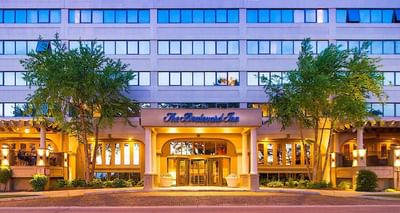 Front view of The Boulevard Inn & Bistro entrance, with a circular drive and two green trees placed outside