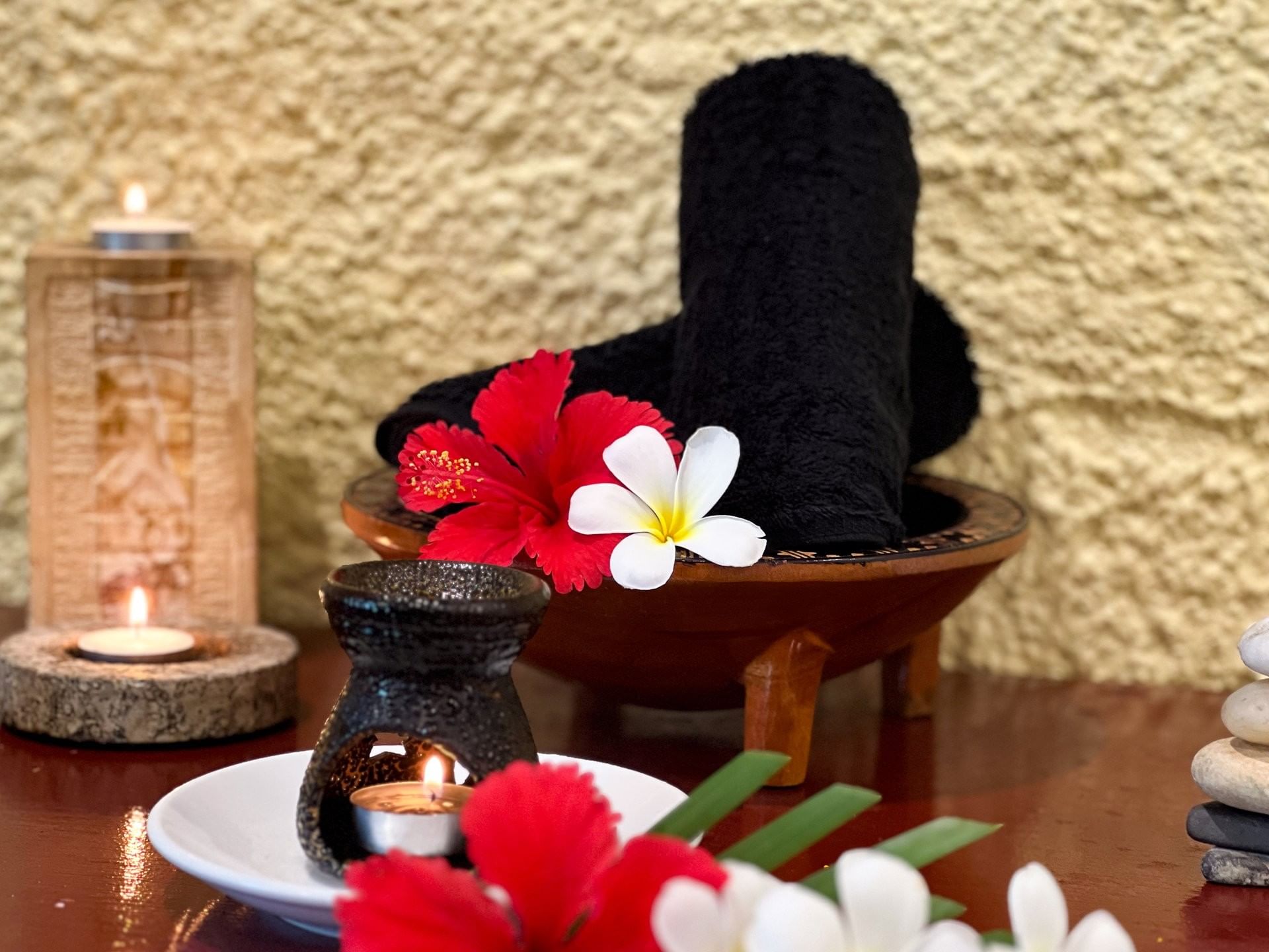 Aromatic oil burner, rolled black towels accented by fresh tropical blooms & soft candlelight at TokaToka Resort Nadi Fiji