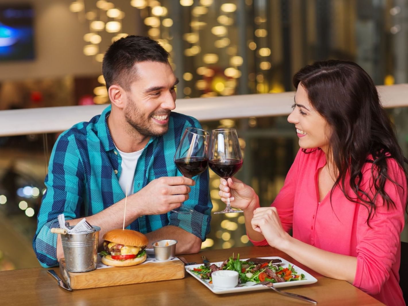 Couple having burger & salad with wine at Carriage House Hotel